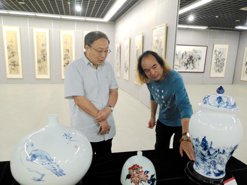 校党委书记穆瑞杰听取王学俊介绍瓷器绘画工艺